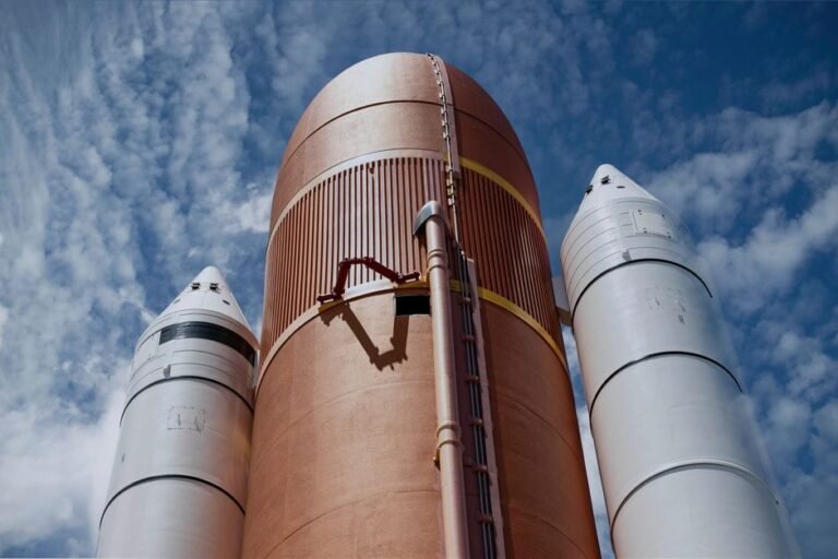 Dramatic view of rocket boosters against a bright blue sky, showcasing aerospace technology.