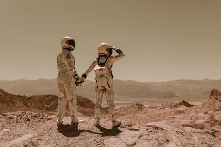 Two astronauts holding hands, exploring rocky Mars-like terrain.