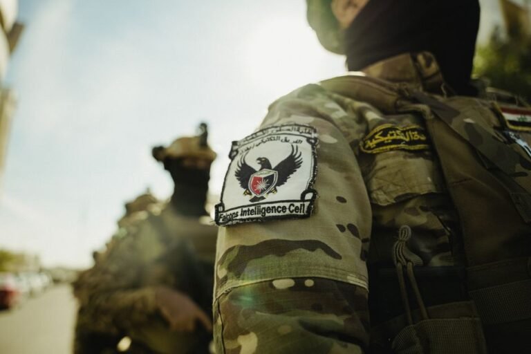 Detailed view of a military uniform with a badge in bright daylight.