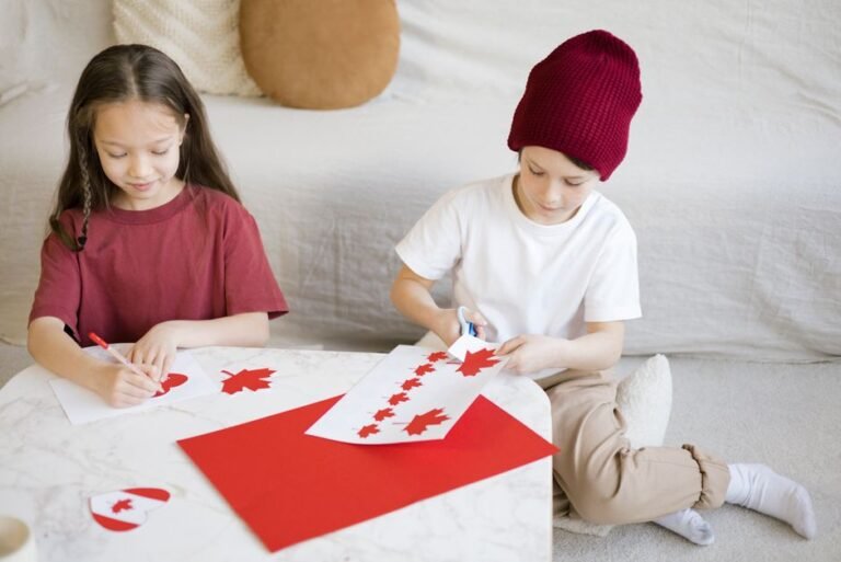Two children engage in crafting Canadian flags indoors to celebrate Canada Day.